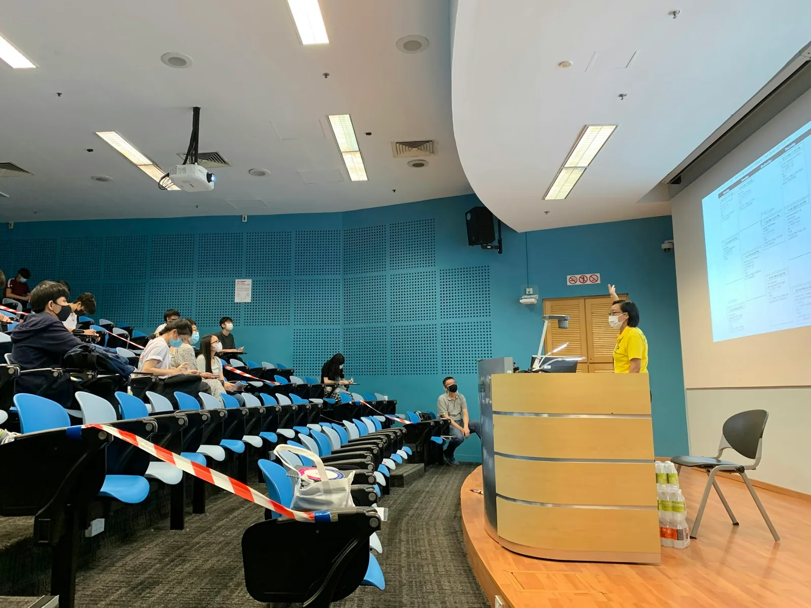 An audience facing a projection screen in a lecture room